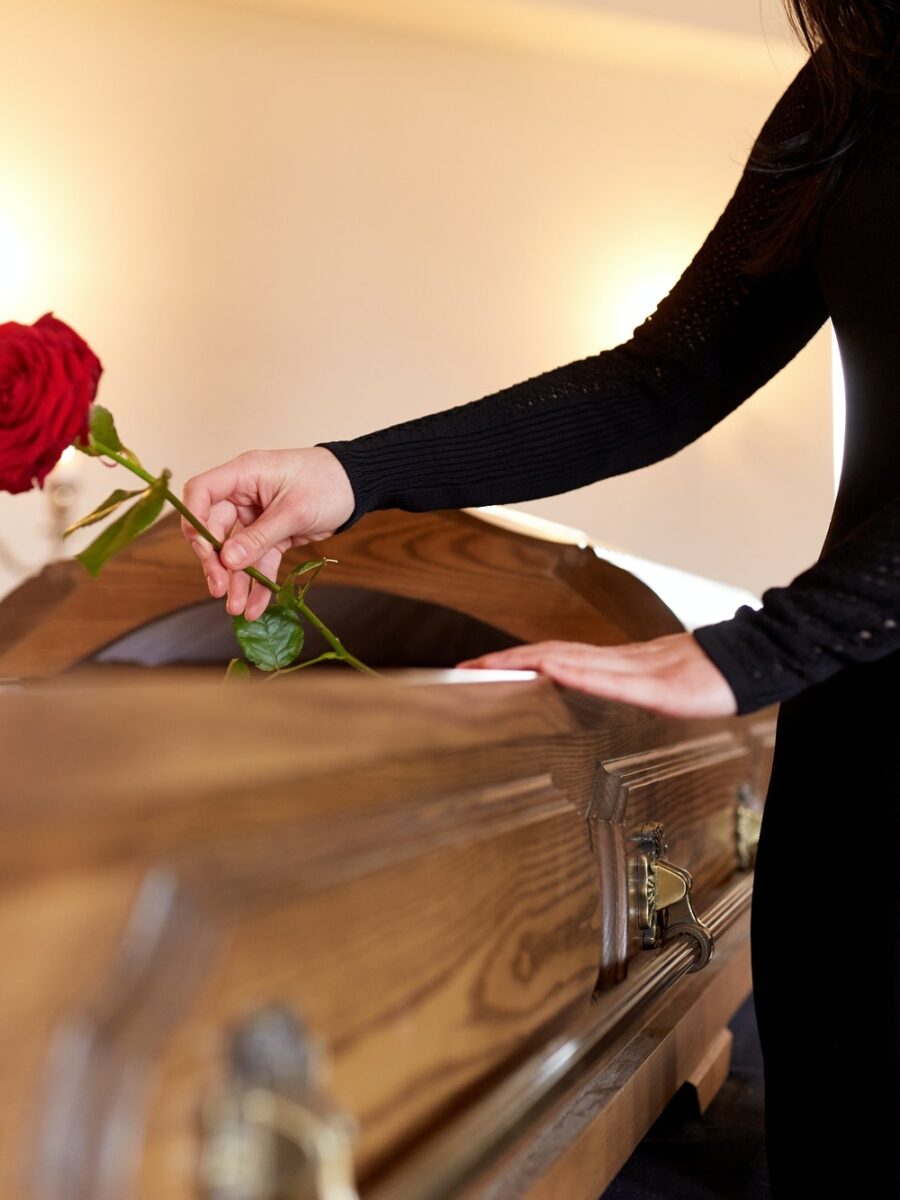 woman-with-red-roses-and-coffin-at-funeral.jpg